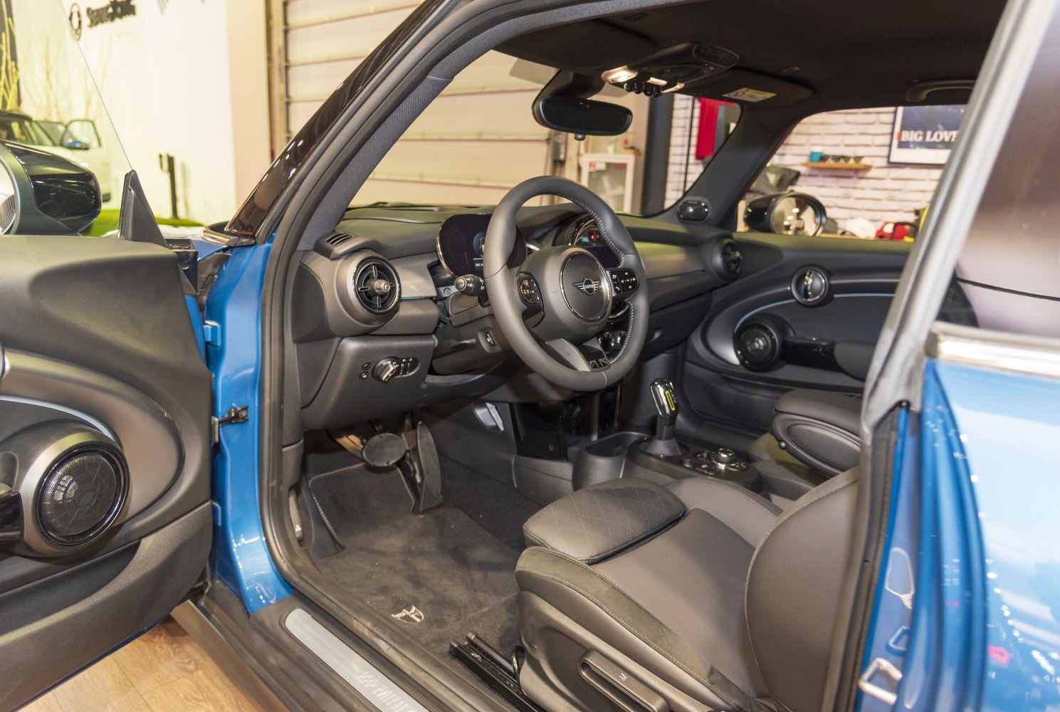 Compact electric car interior with modern steering wheel and dashboard.