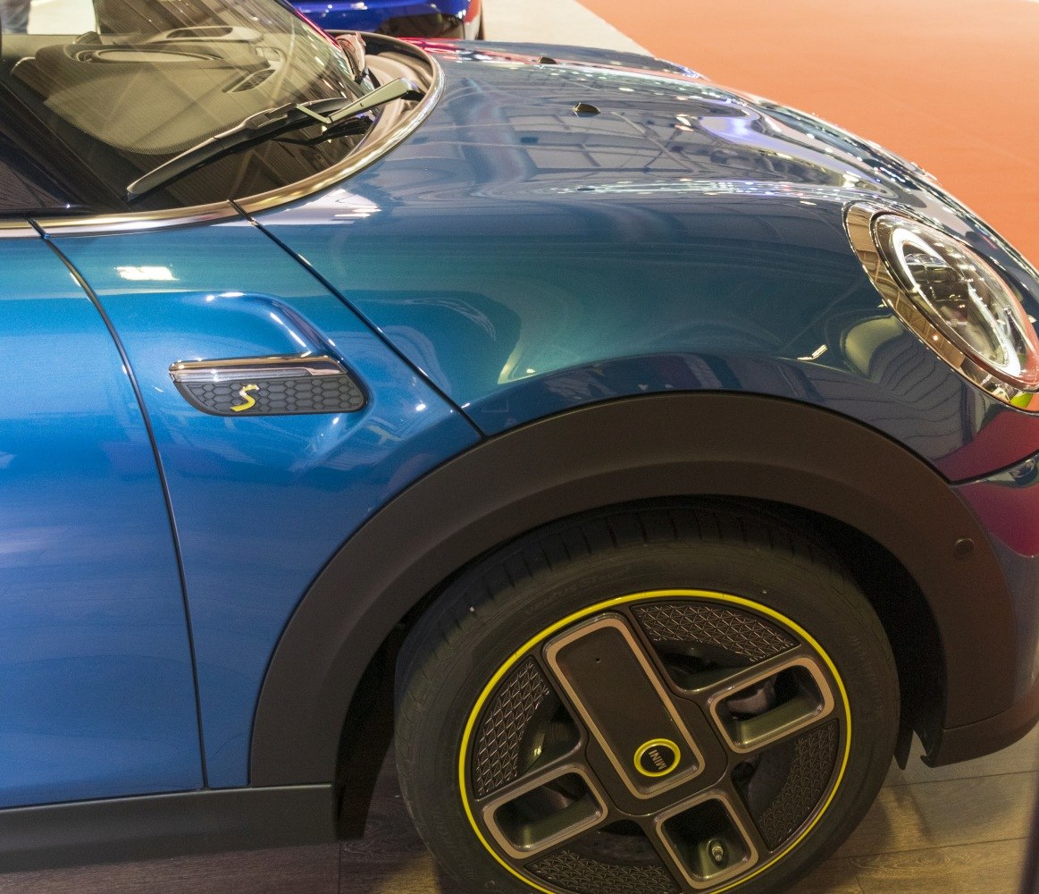 Close-up of front wing with electric 'S' emblem and unique yellow-accented wheel design