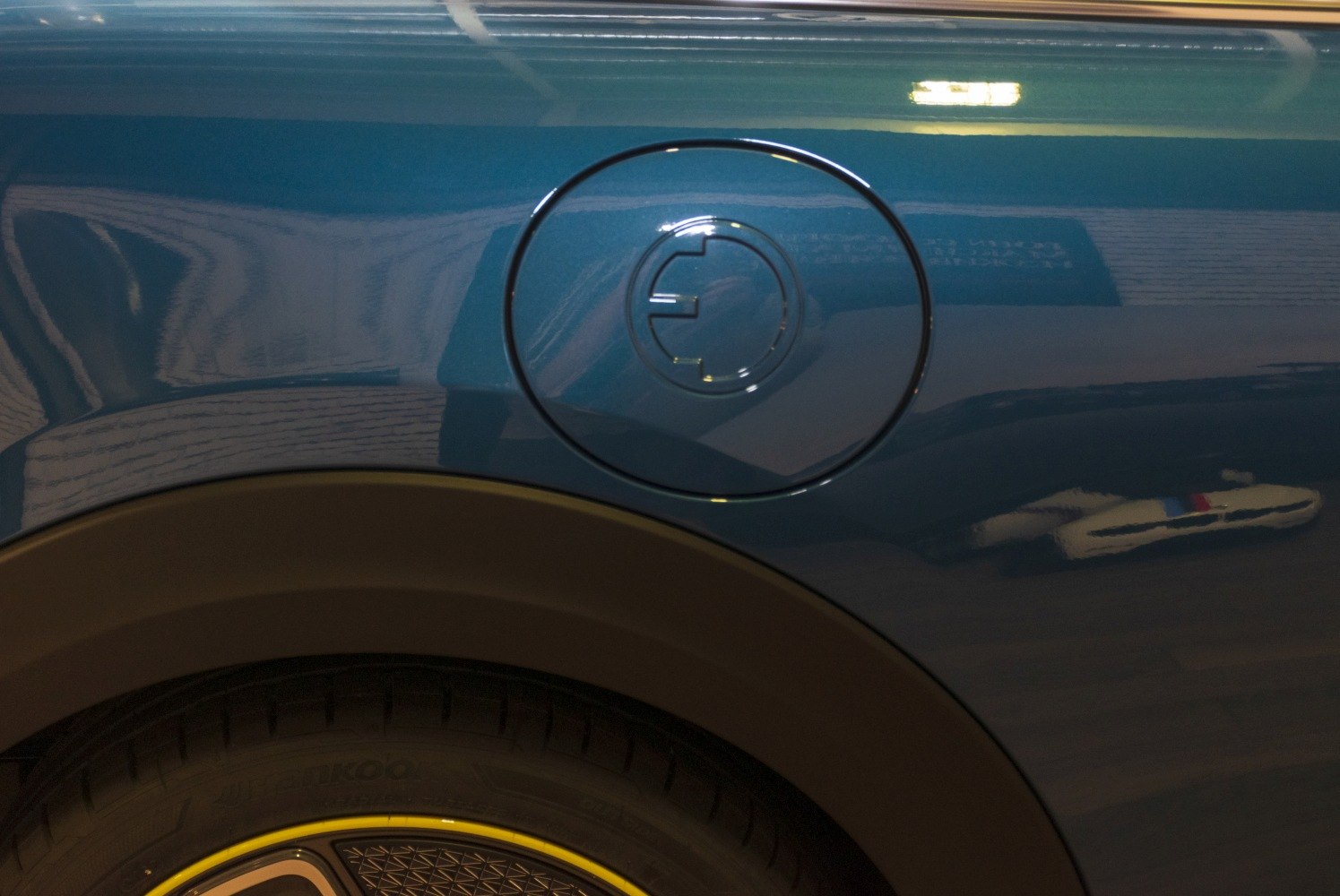 Electric charging port and wheel detail on a compact electric vehicle