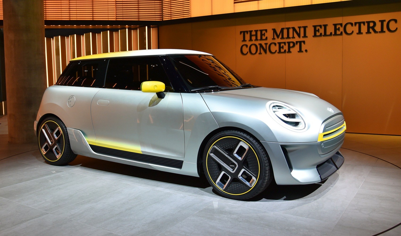 Silver electric hatchback with yellow accents and futuristic design elements