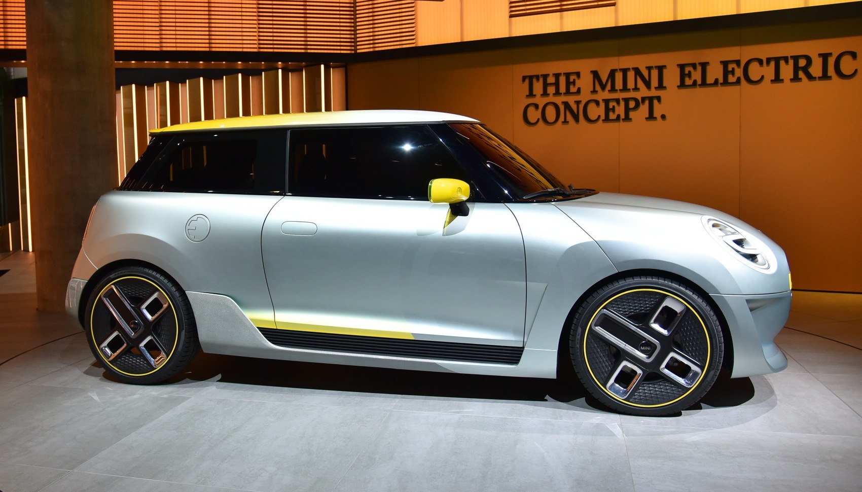 Side profile of a sleek electric concept car with futuristic wheels.