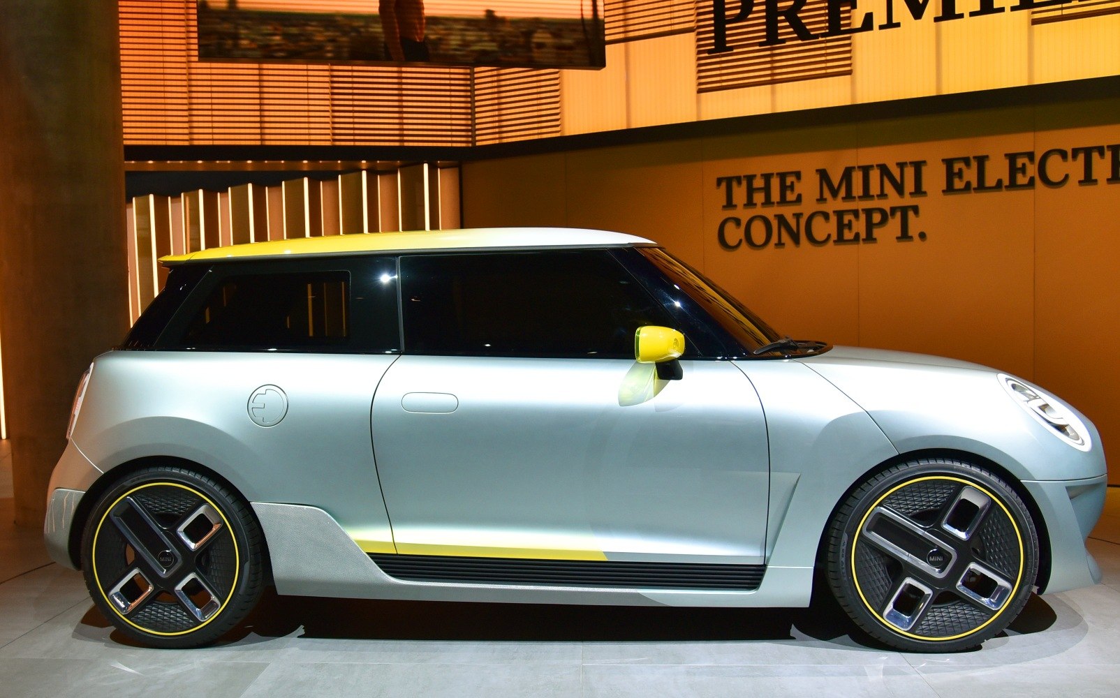 Sleek electric hatchback with yellow accents and futuristic wheel design