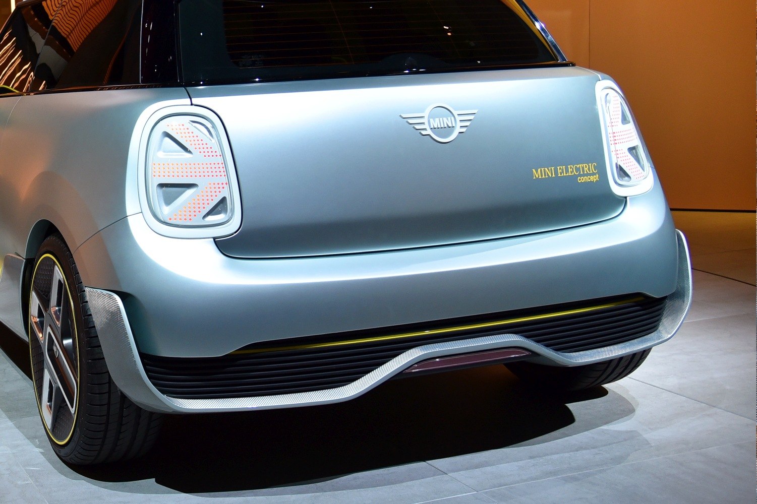 Futuristic Union Jack taillights and sleek rear bumper of a compact electric concept vehicle.