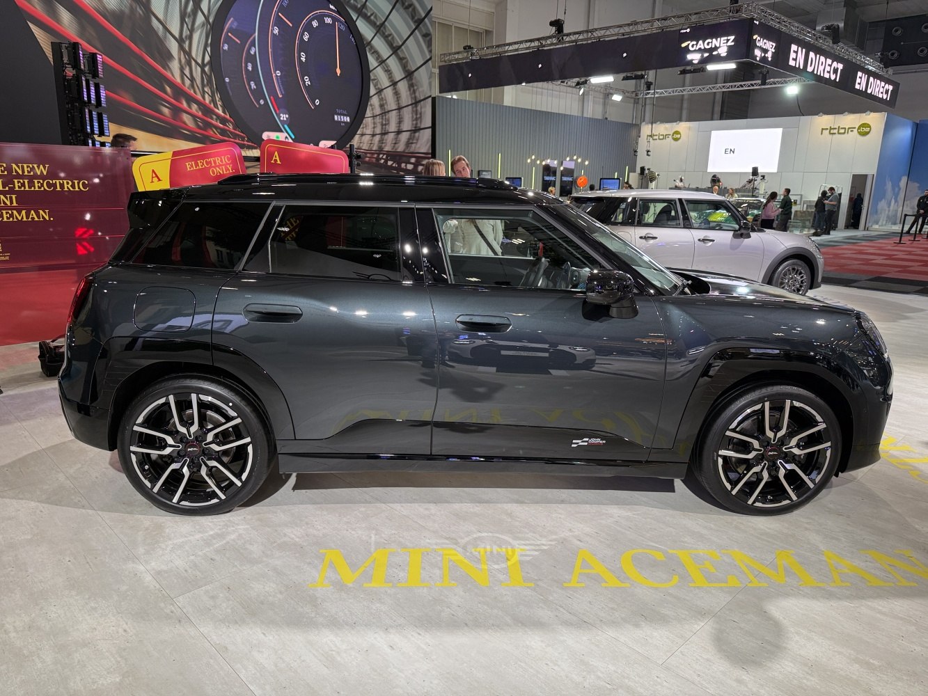 Side profile of an electric SUV with alloy wheels in glossy black.