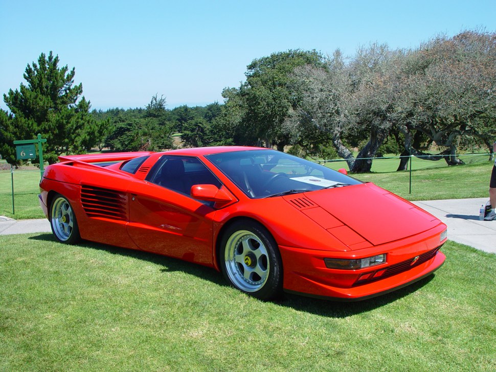Red mid-engine sports coupe with side air intakes and alloy wheels