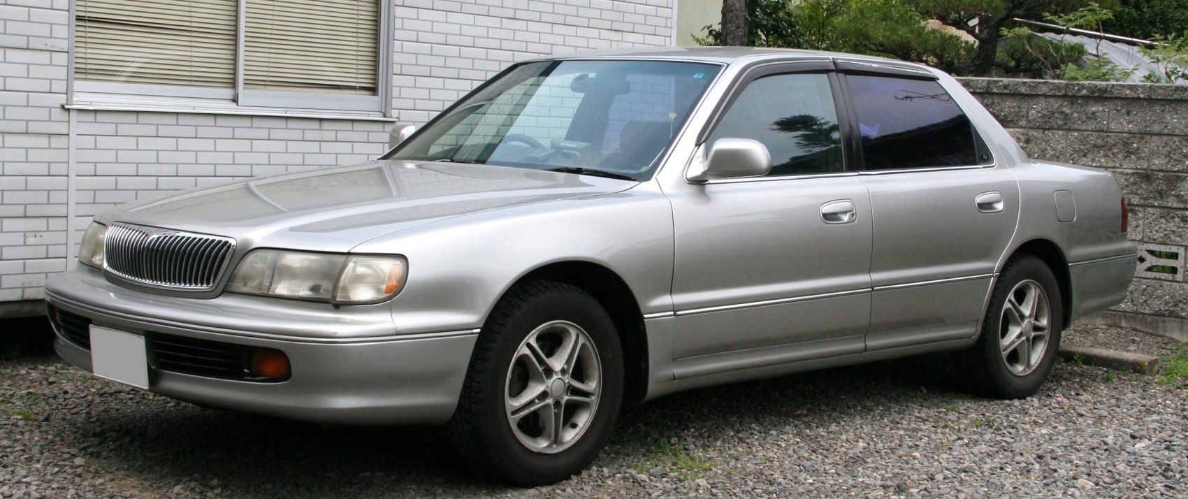 Front side view of silver sedan with alloy wheels and classic design