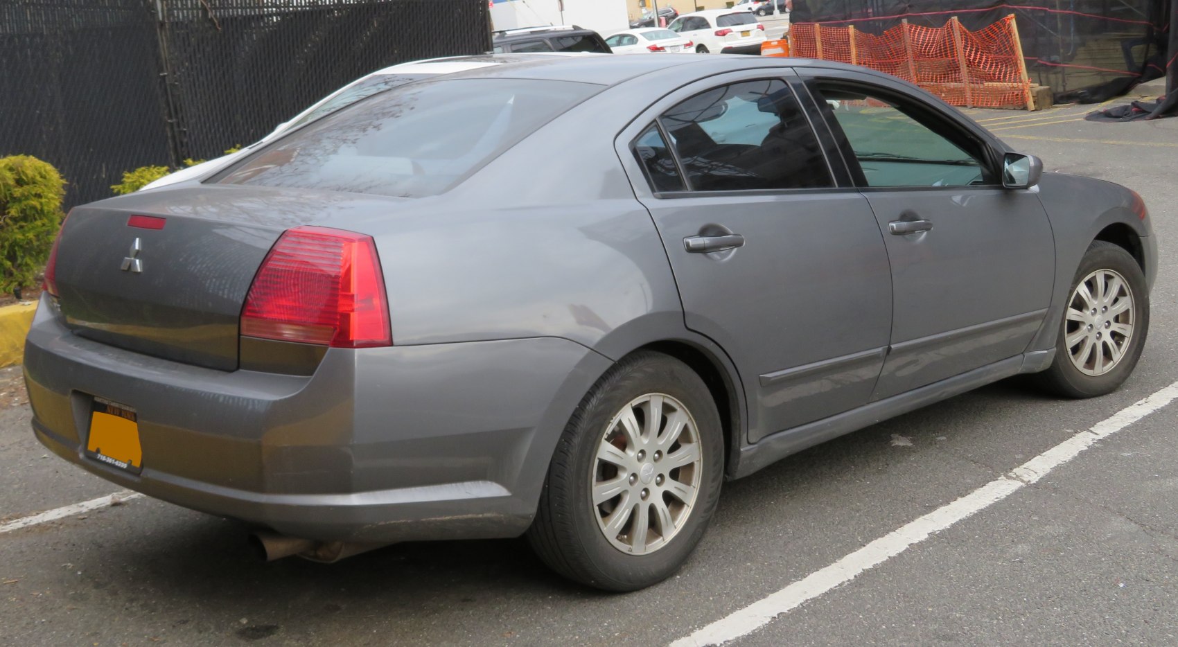 Rear-side view of a gray mid-size sedan with alloy wheels