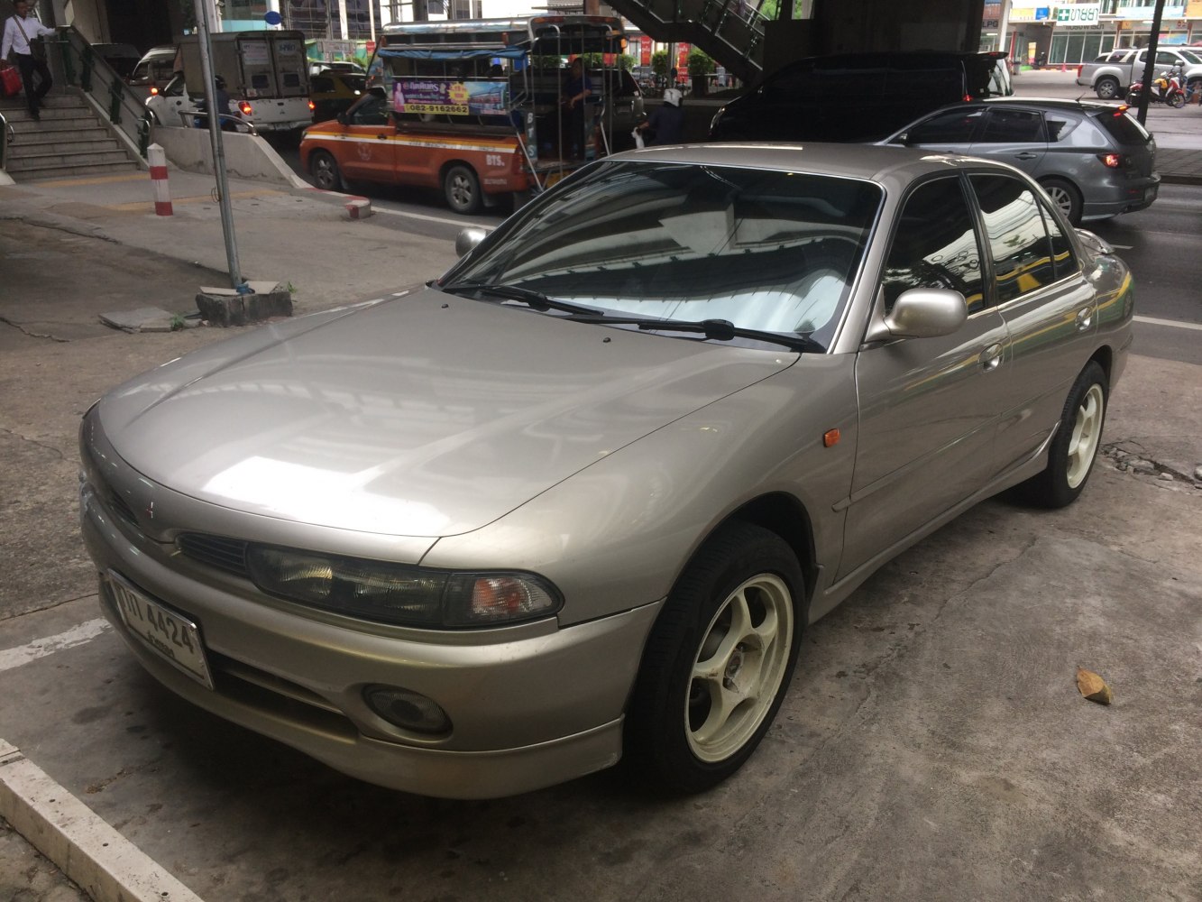 Front-side view of a 1990s sedan with alloy wheels.