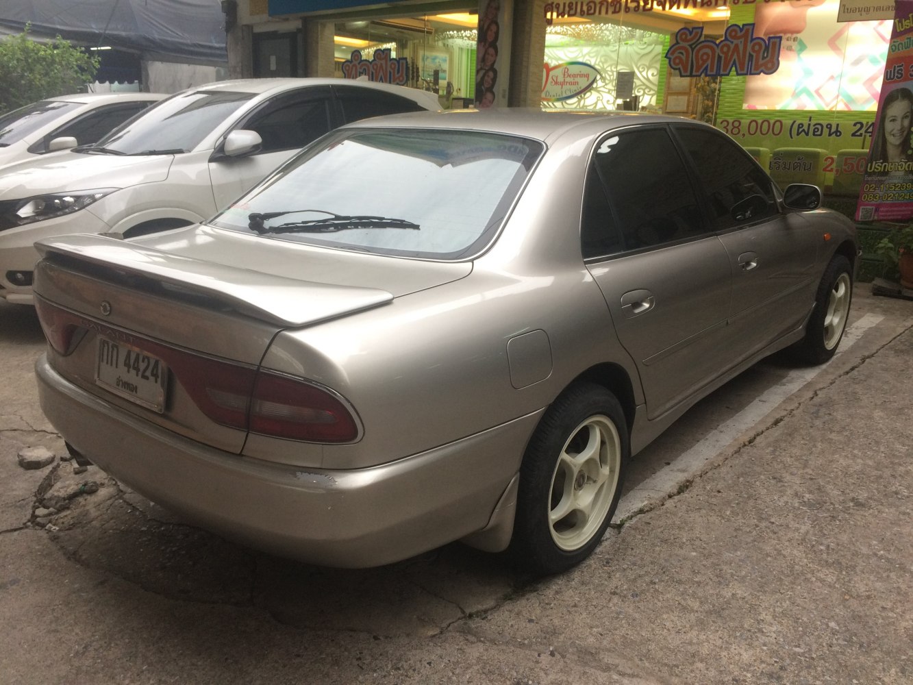 Sedan with rear spoiler, tinted windows and unique tail lights.