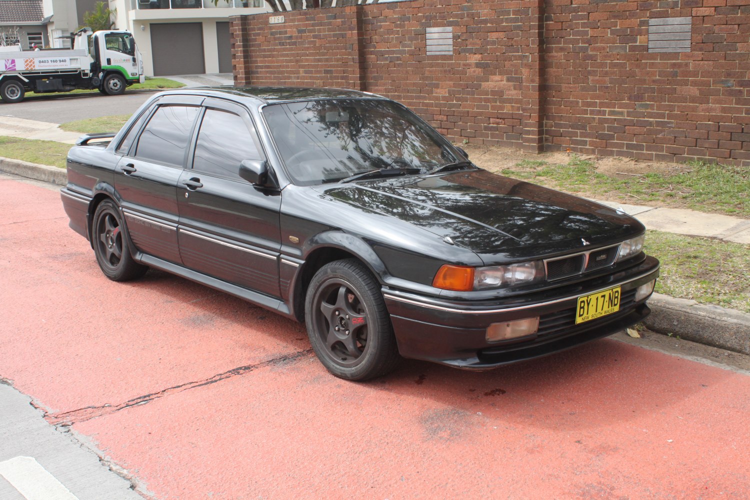 Black sedan with sporty alloy wheels and rear spoiler