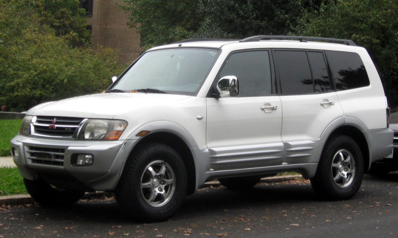 Front side view of an SUV with chrome side mirrors and rugged tires