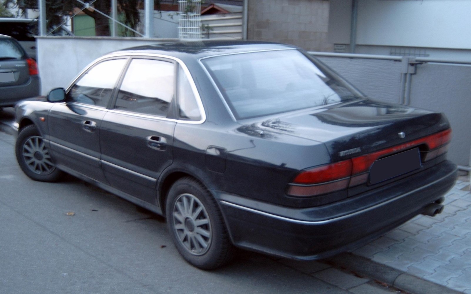 Rear side profile with tail lights and wheel design of a sedan.