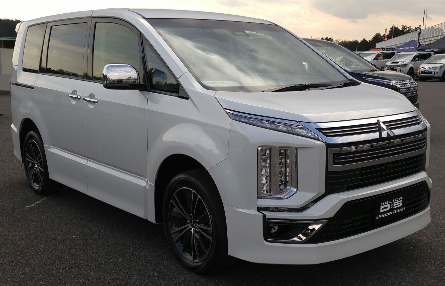 Front side view of mid-size van with LED headlights and chrome grille