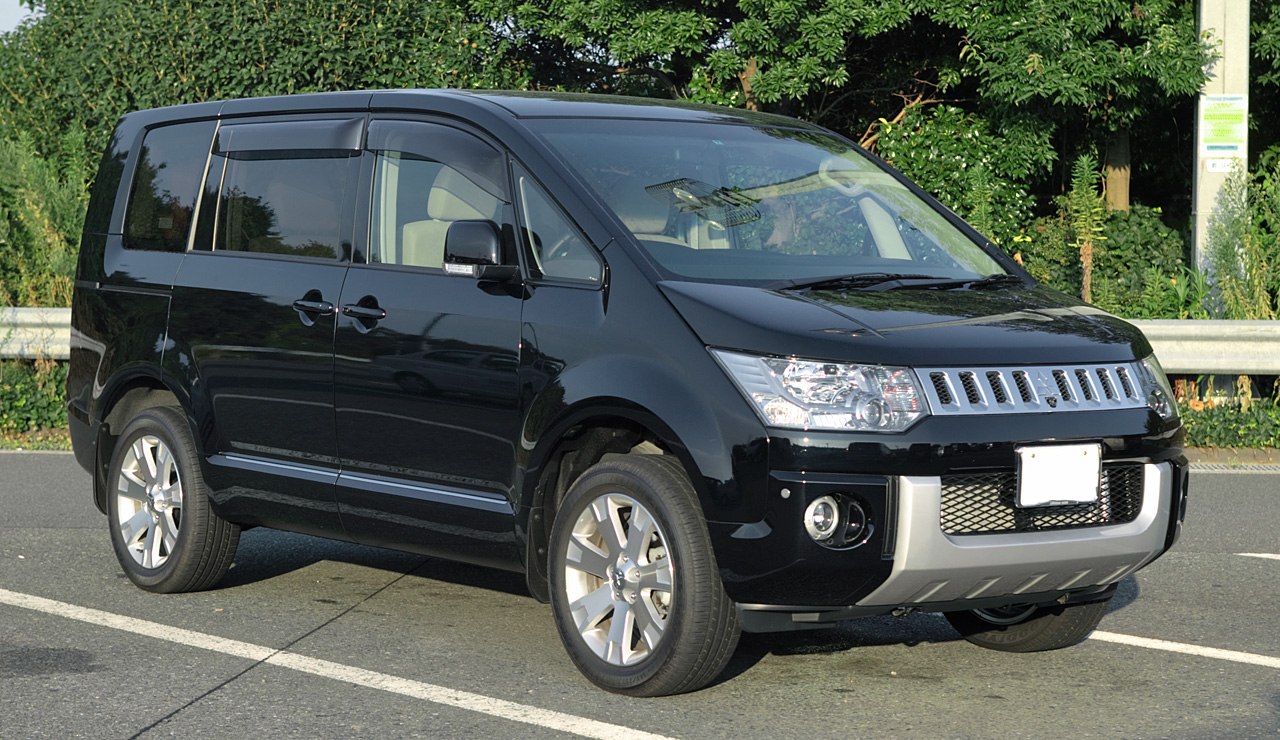 Front side view of a modern minivan with striking grille and alloy wheels