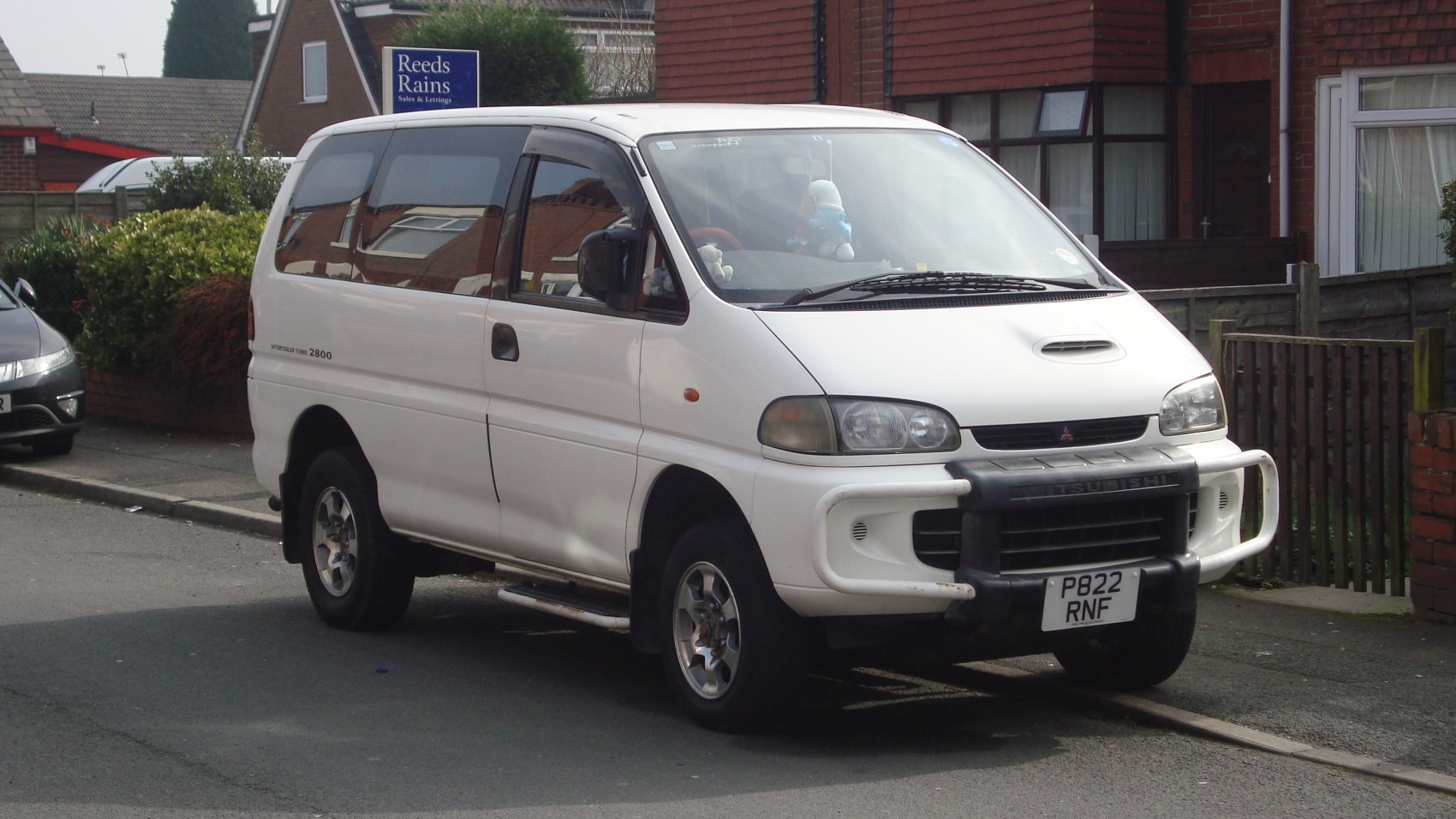 White minivan with off-road front bull bar and hood scoop