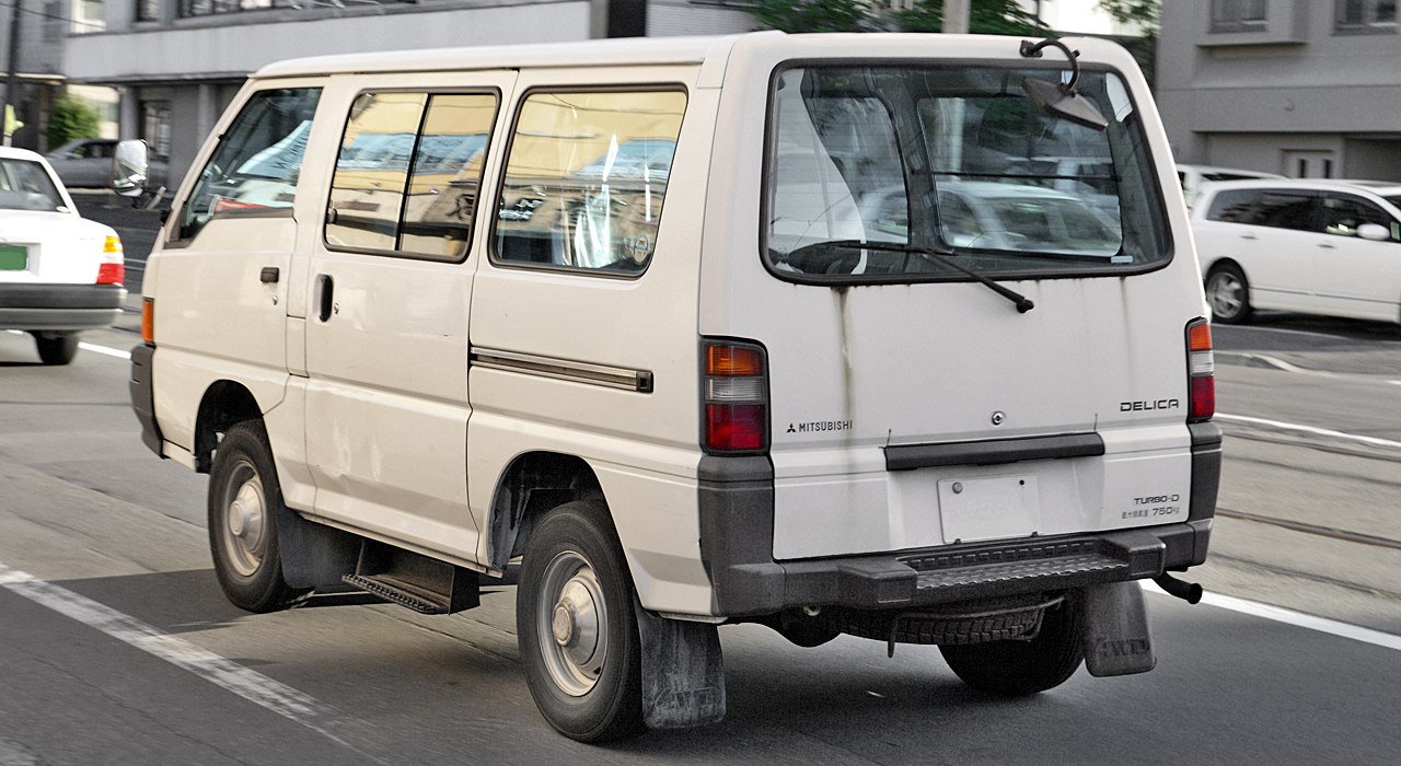 Rear view of white boxy van with rectangular taillights and rear wiper