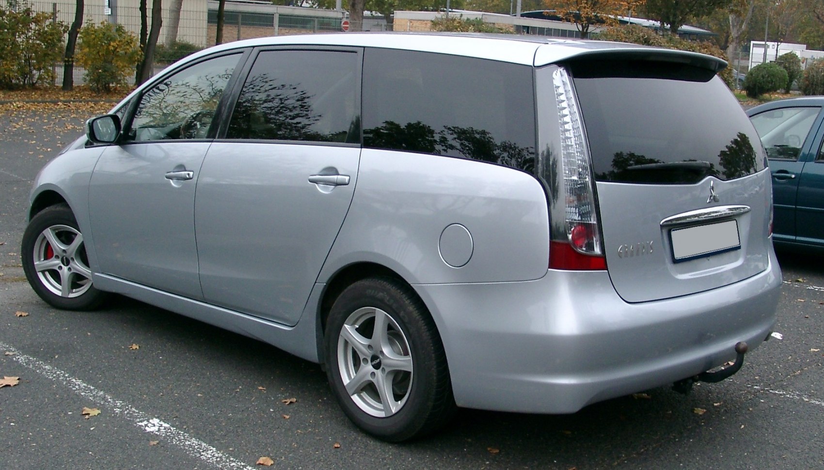 Silver MPV rear-side with tall vertical tail lights and five-spoke alloy wheels