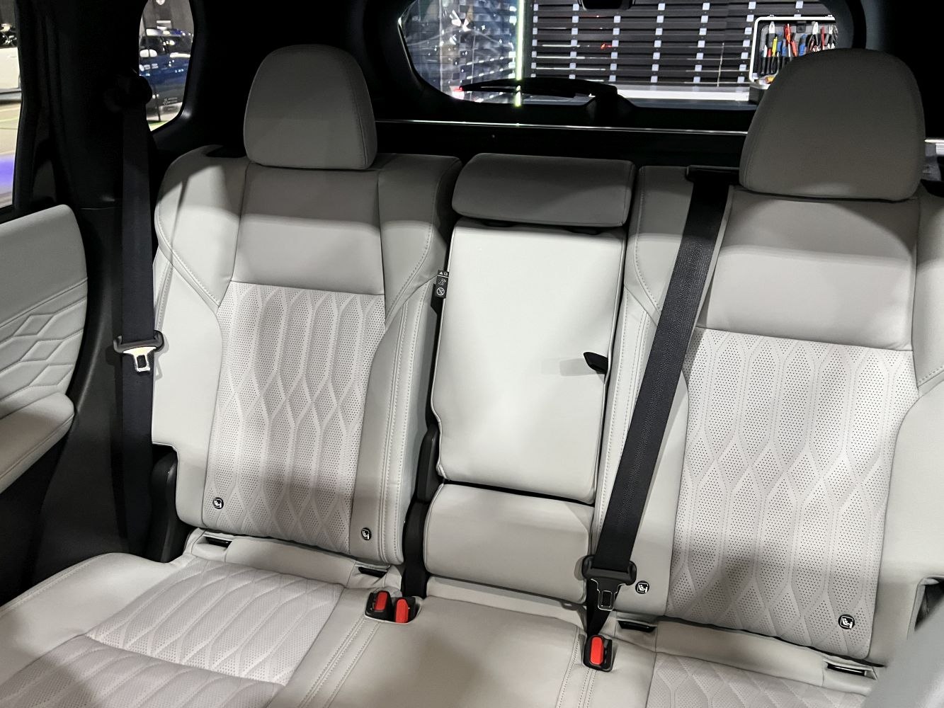 Rear seats with light gray perforated leather upholstery and safety belts