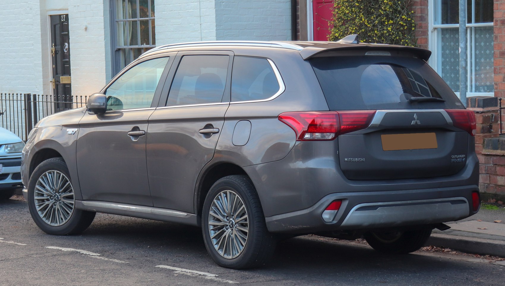 Rear side profile of an SUV with hybrid badge, alloy wheels, tinted rear windows
