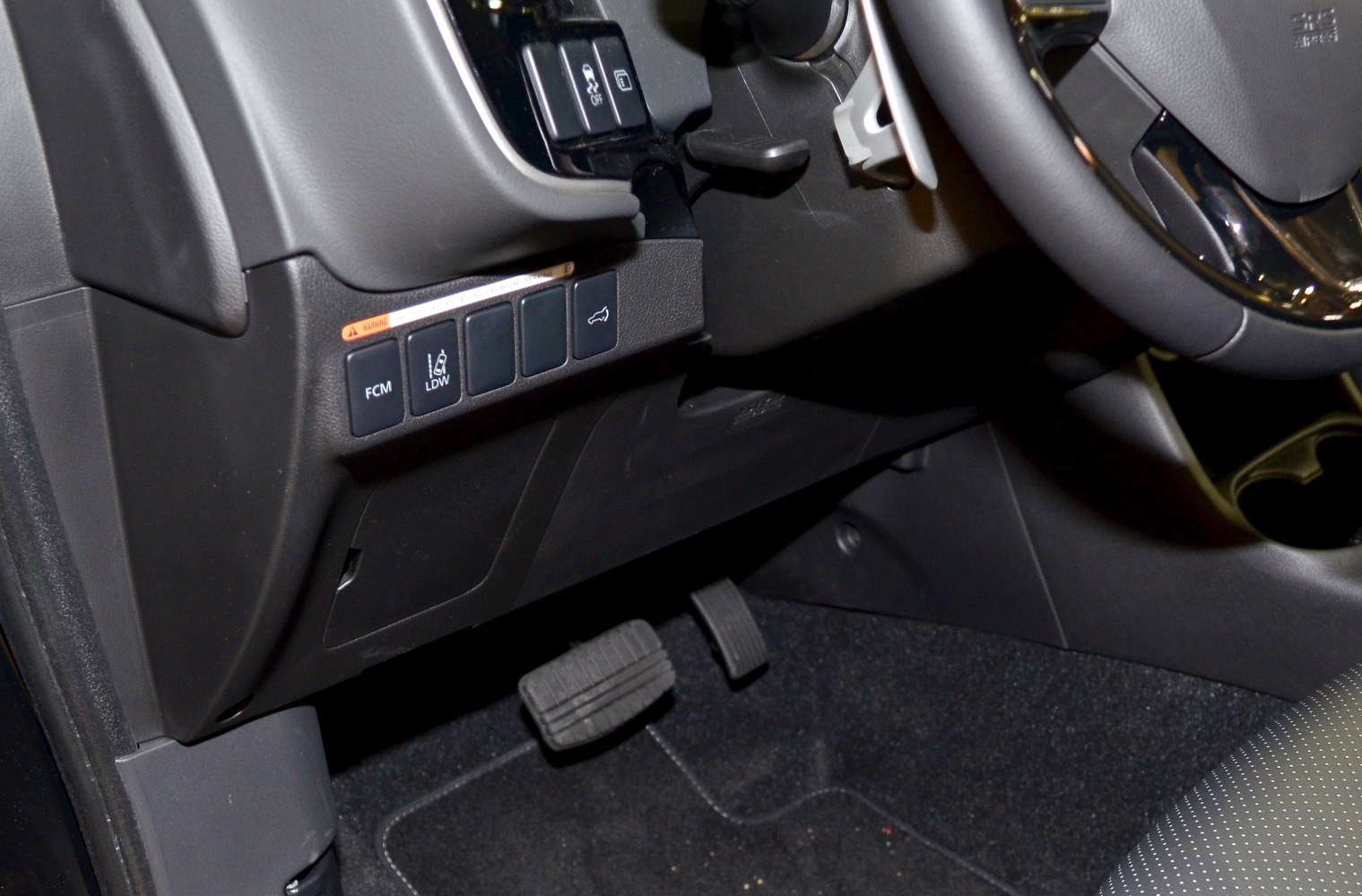 Driver assistance control buttons and pedal area inside car cabin