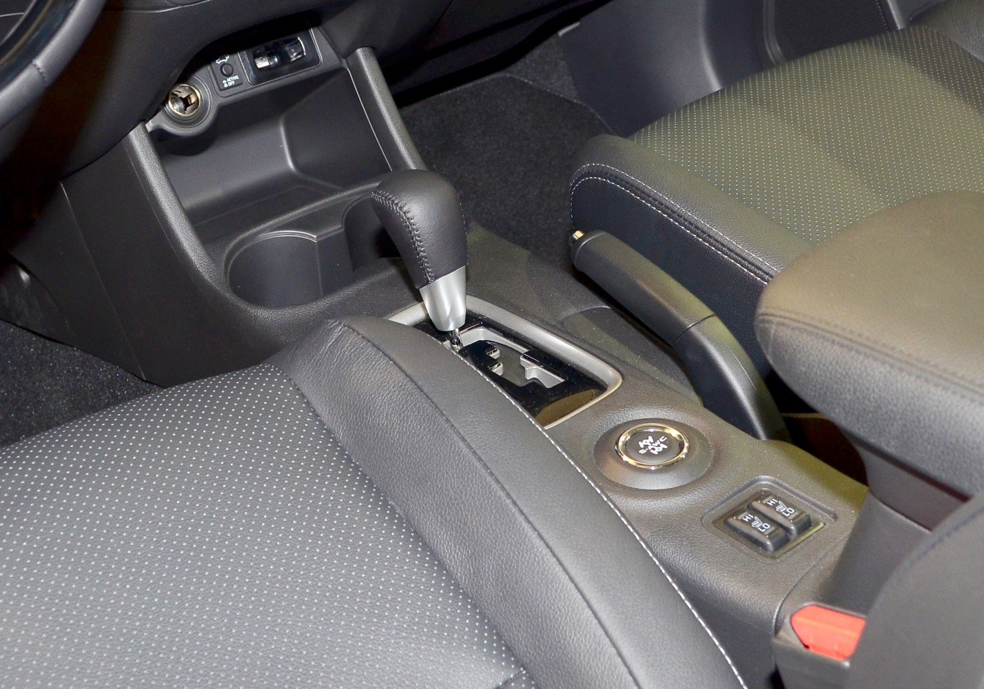 Close-up of gear shift and center console with controls and seats