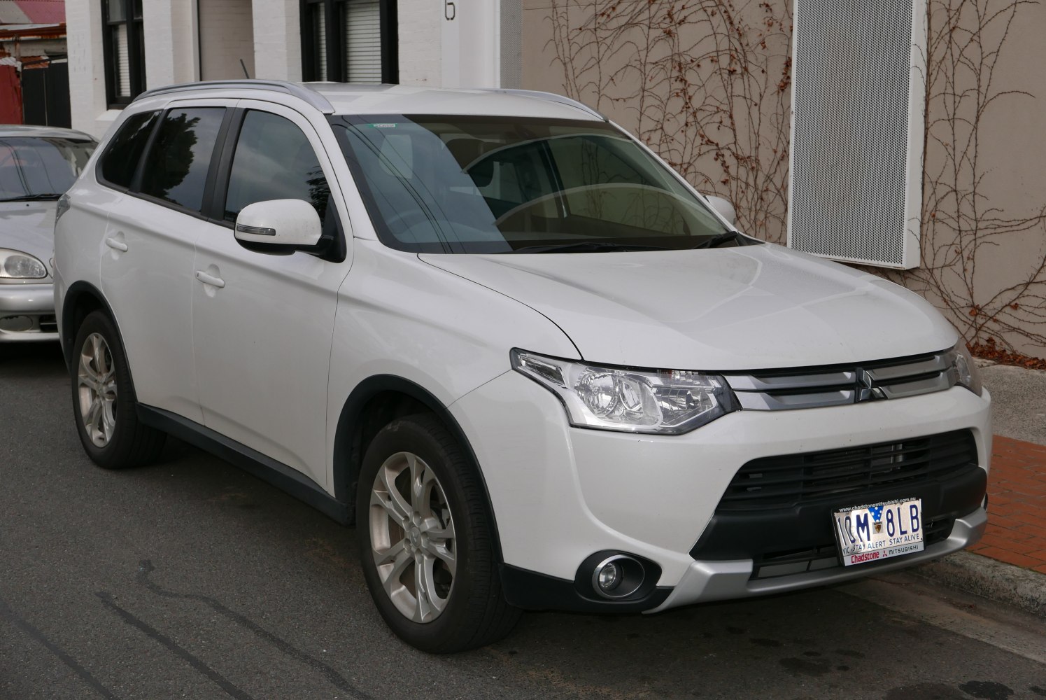 Front view of white SUV with alloy wheels and roof rails.