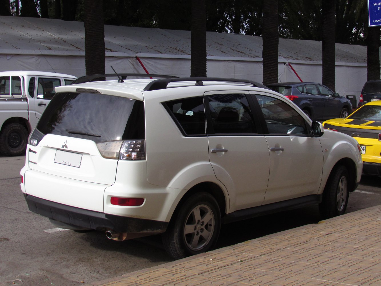 Rear side view of white SUV with roof rails and tinted windows