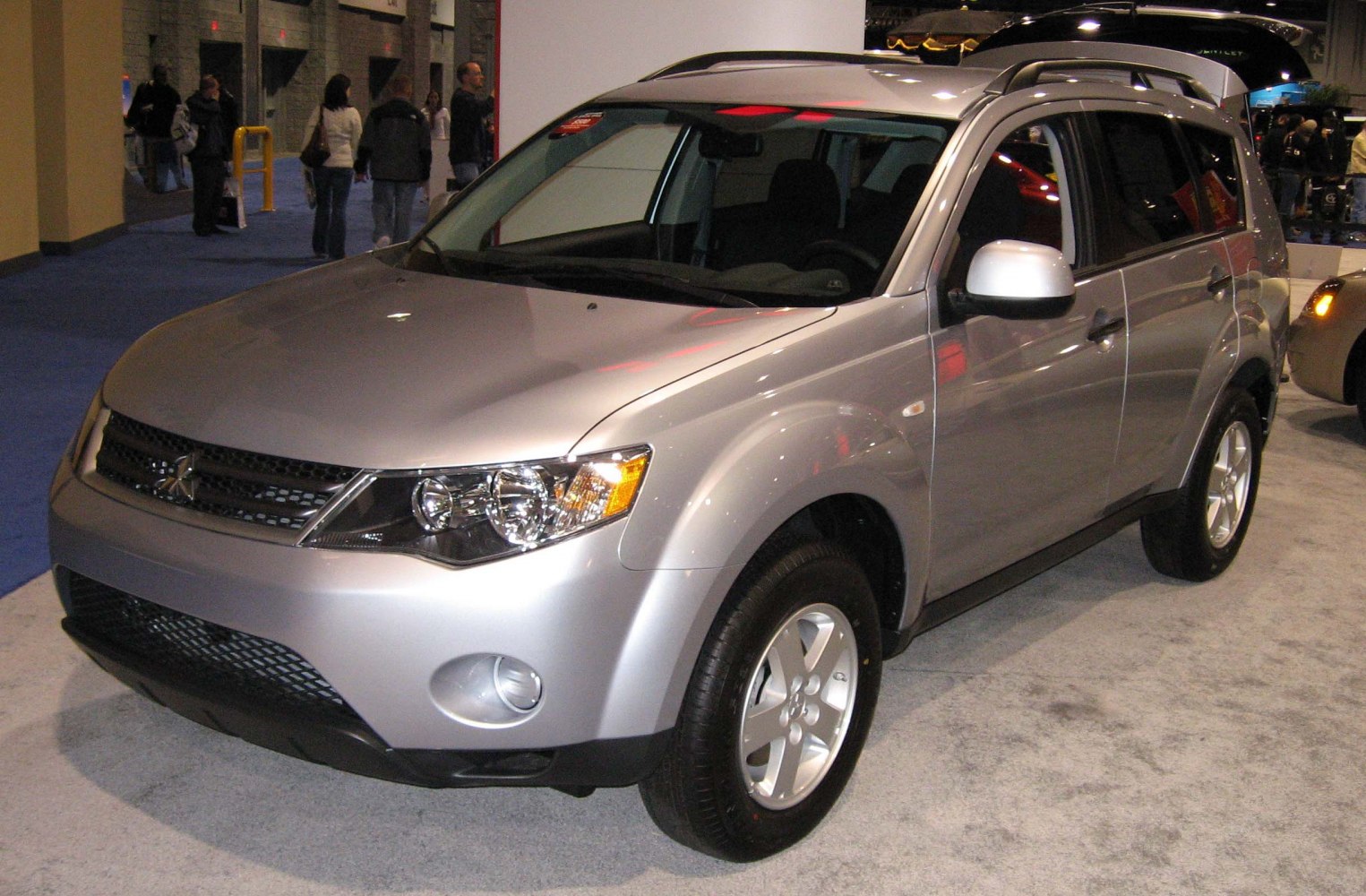Front and side view of a silver SUV with distinct headlights and alloy wheels