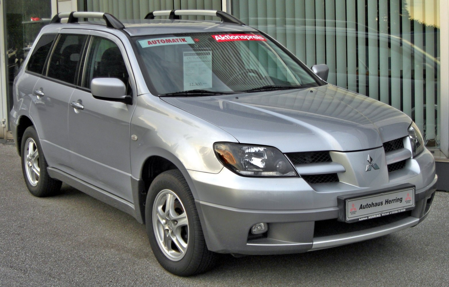 Silver SUV with roof rails and alloy wheels, front-side view