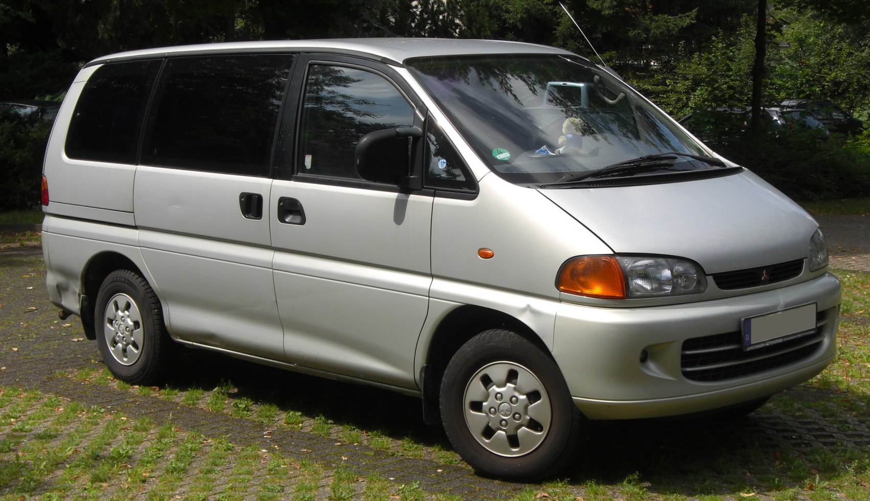 Front and side view of a minivan with sliding door and alloy wheels