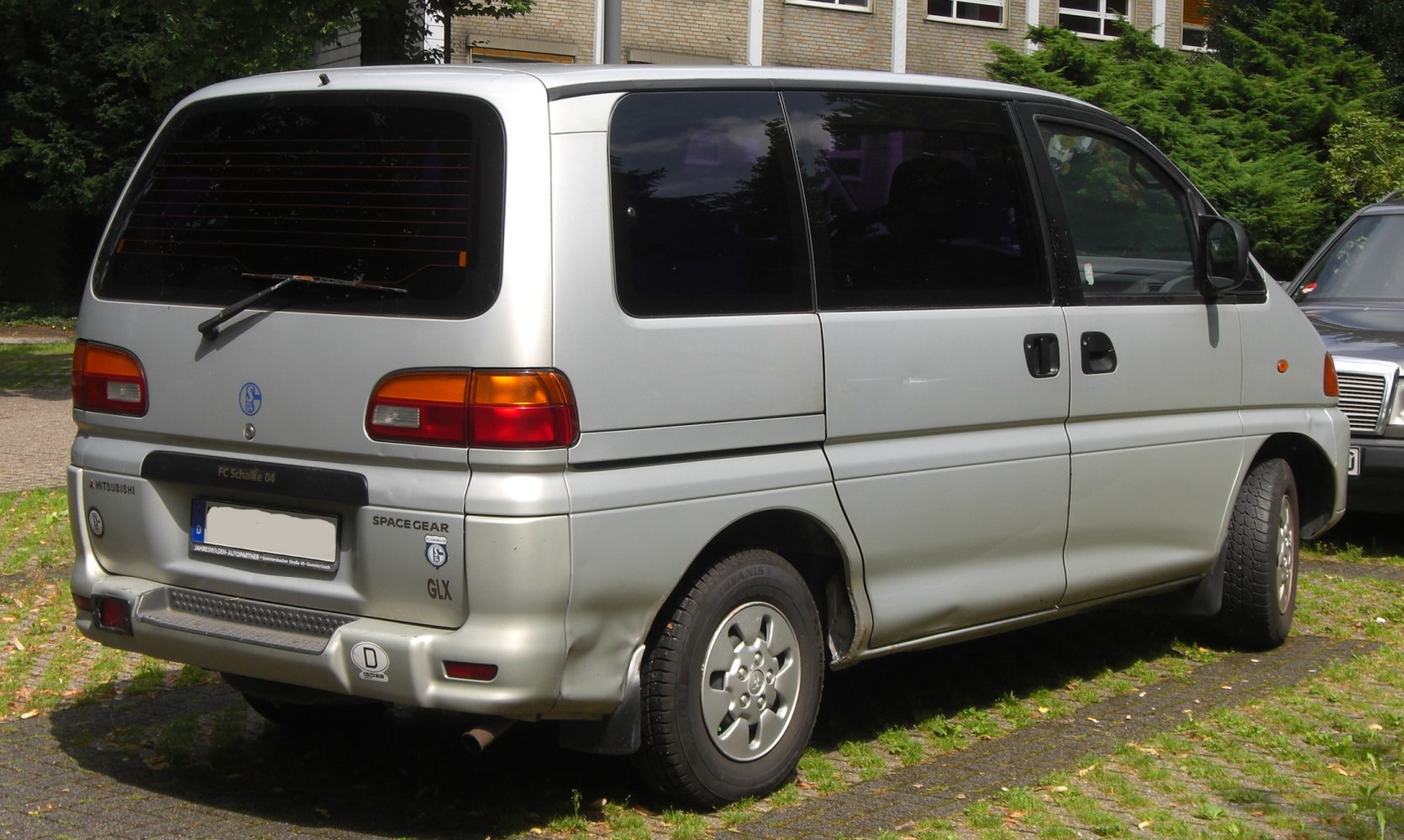 Rear and side of minivan with sliding door, tinted windows, rear wiper