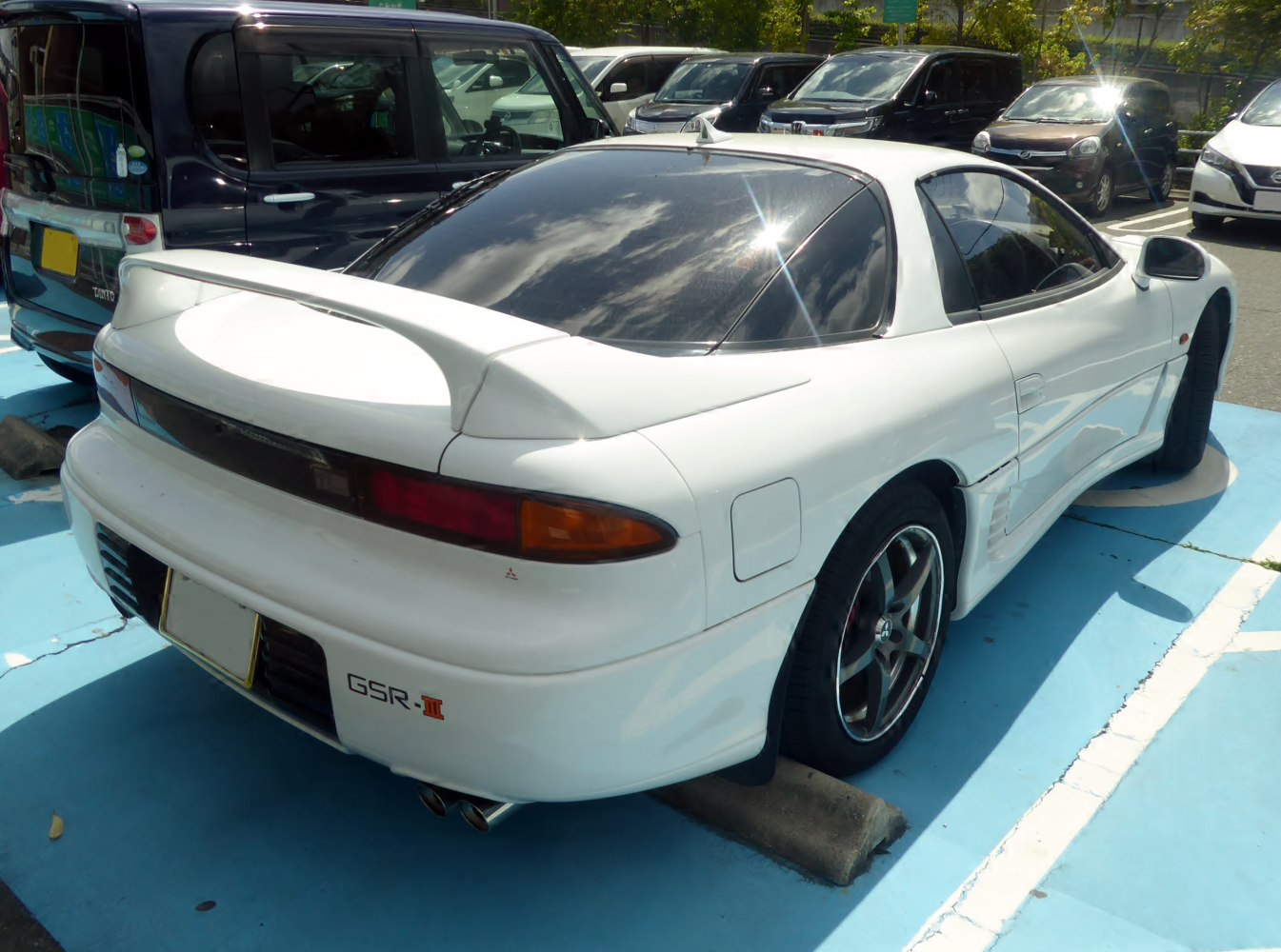 White sports coupe with rear spoiler and dual exhaust