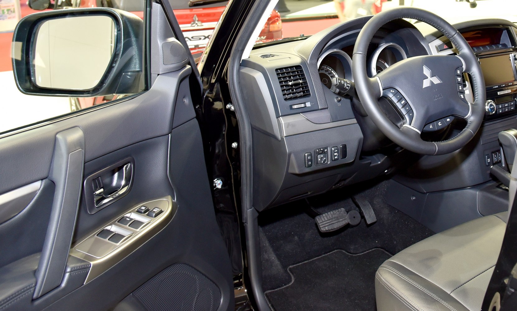 Steering wheel and driver's side door panel with control buttons