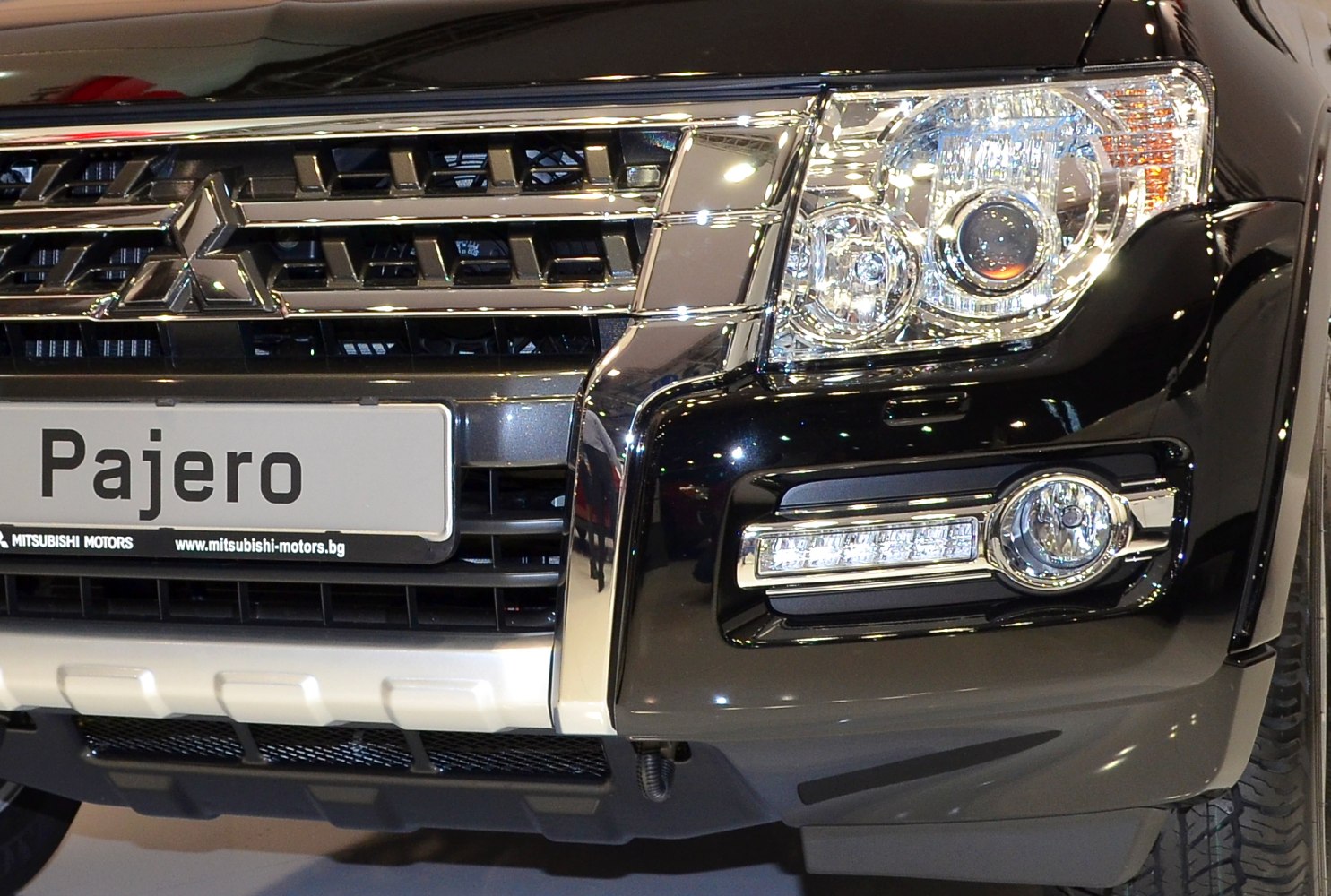 Close-up of SUV front grille and headlight design with fog lamp