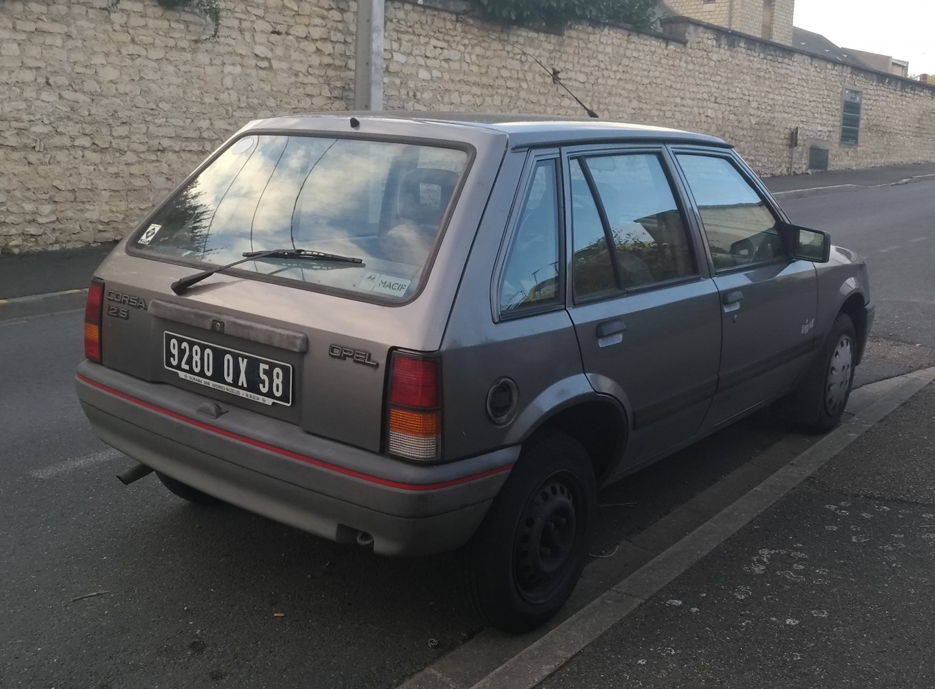 Rear and side view of a 1990s compact hatchback with tail lights and rear wiper
