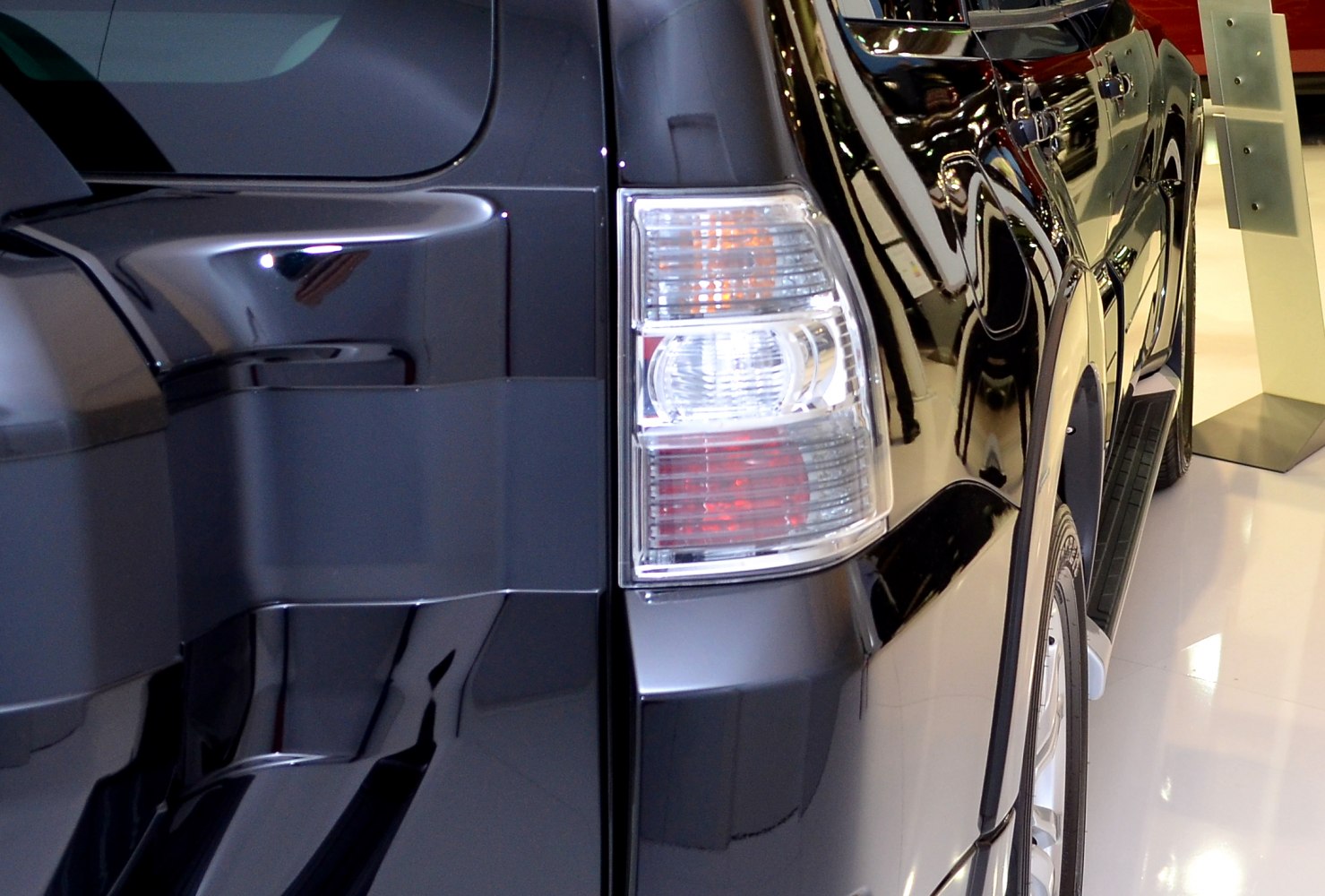 Close-up rear light and side body with glossy black paint.