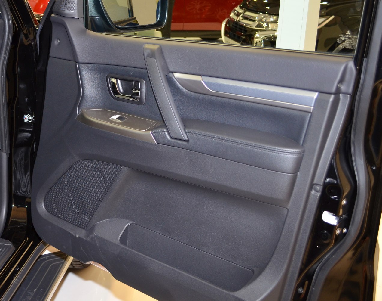 Interior door panel with armrest, door handle, speaker, and window switch