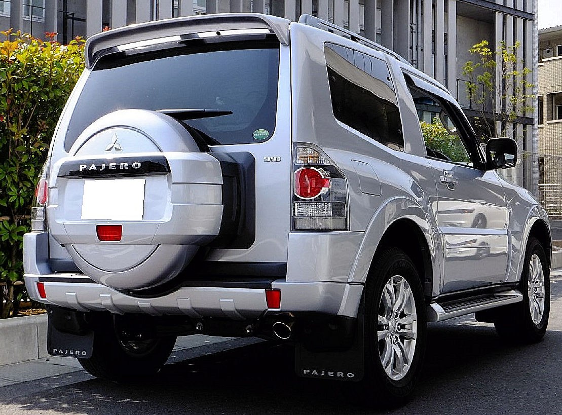Rear view of SUV with spare tire cover, tail lights, alloy wheels, and mud flaps