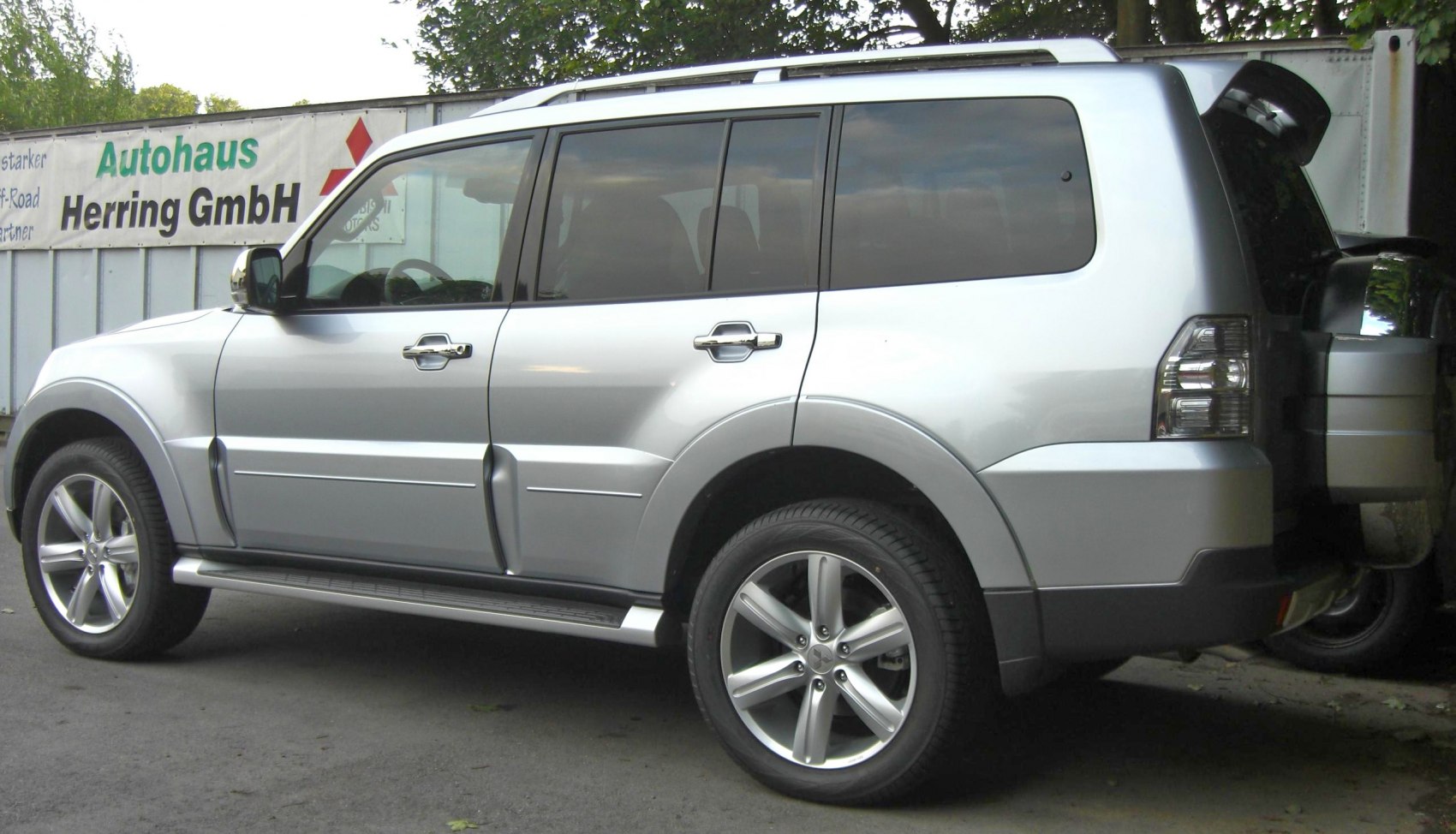 Silver SUV side view with alloy wheels and rear spare tire