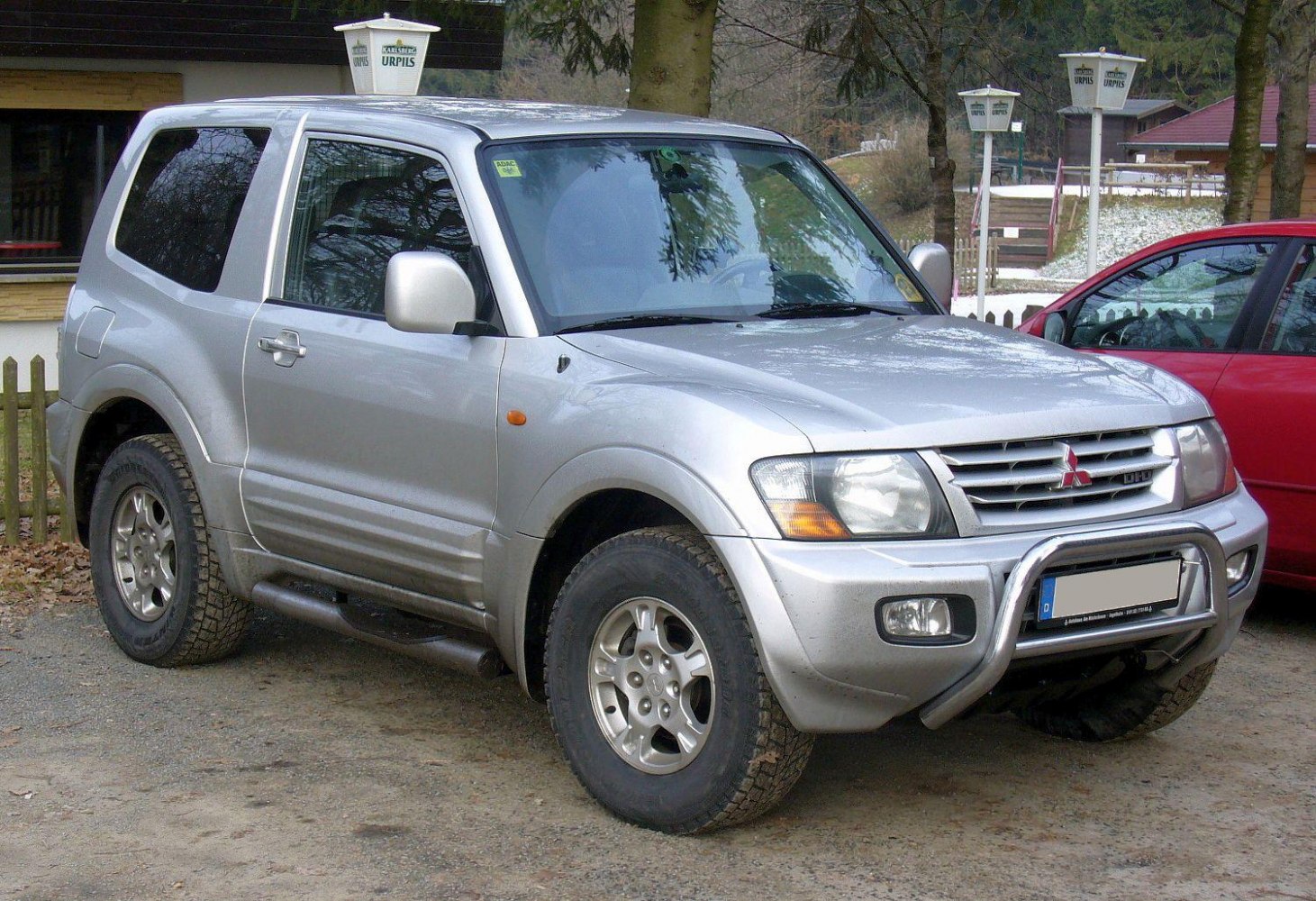 Silver SUV with alloy wheels and front bullbar on rough ground