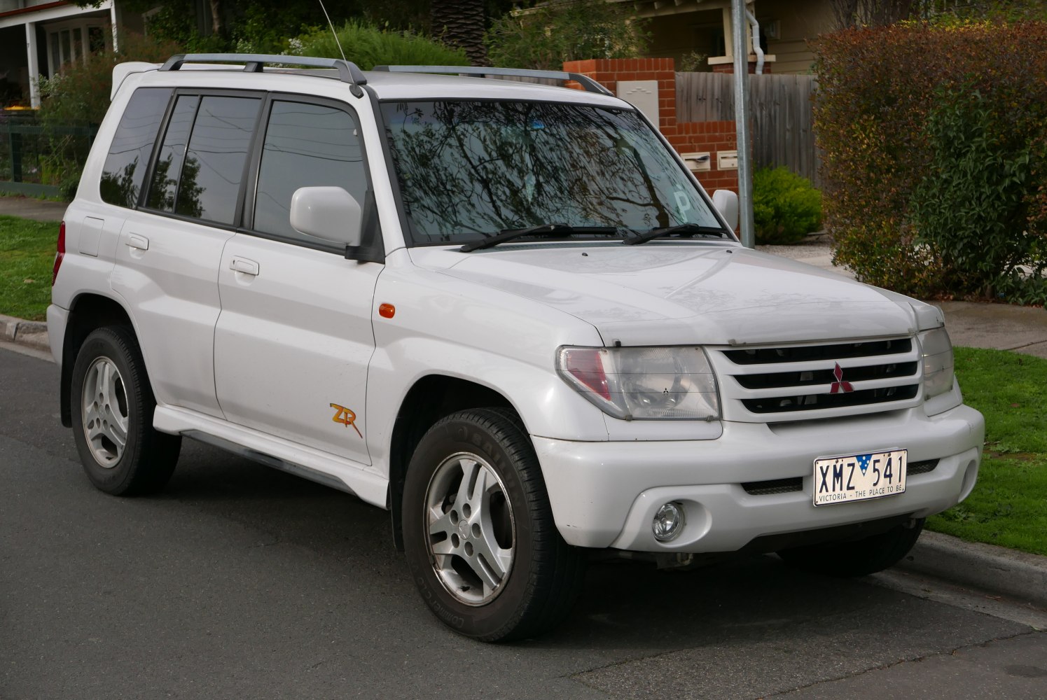White SUV front side view with alloy wheels and roof rails