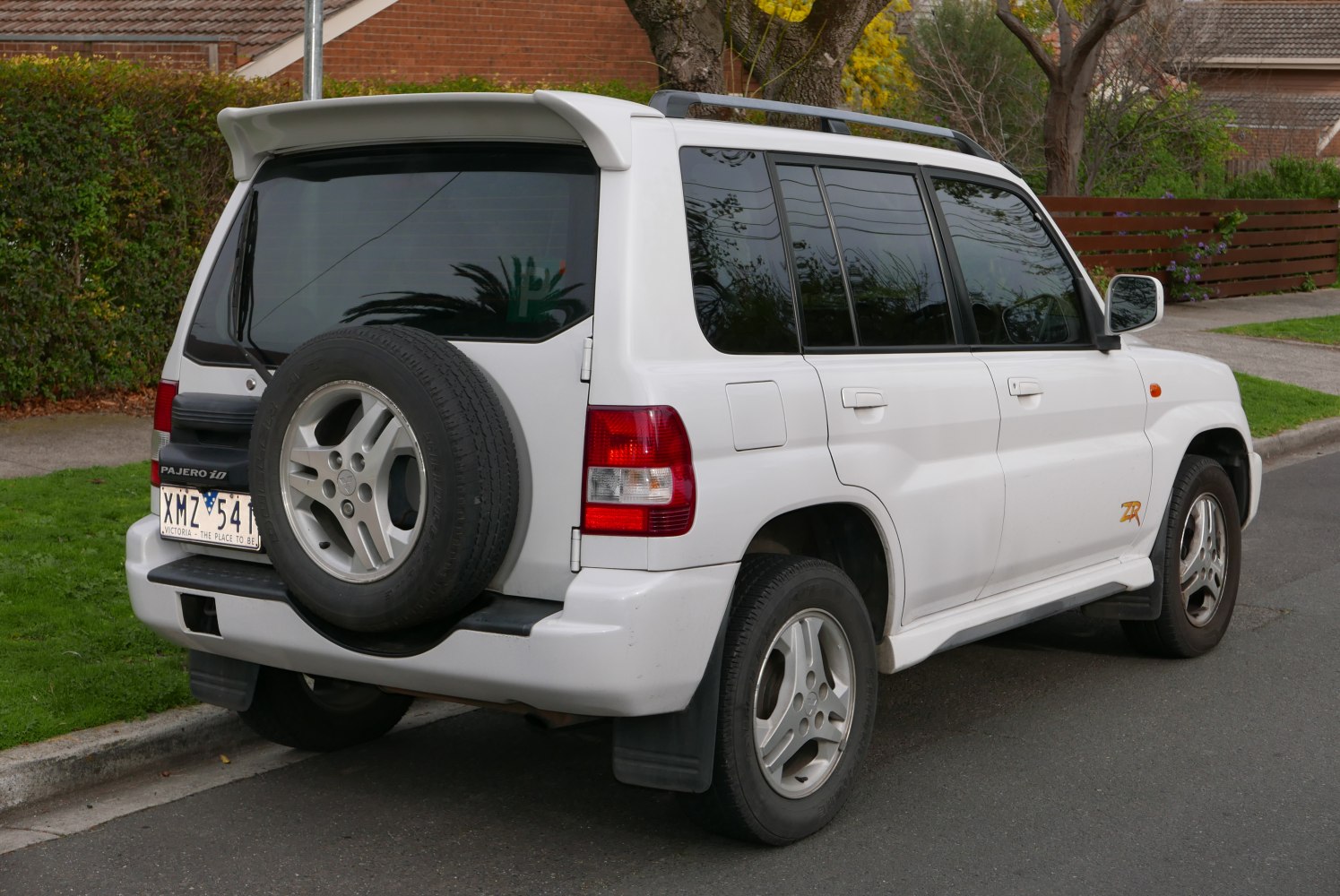 Rear side view with spare tire and rear wing spoiler