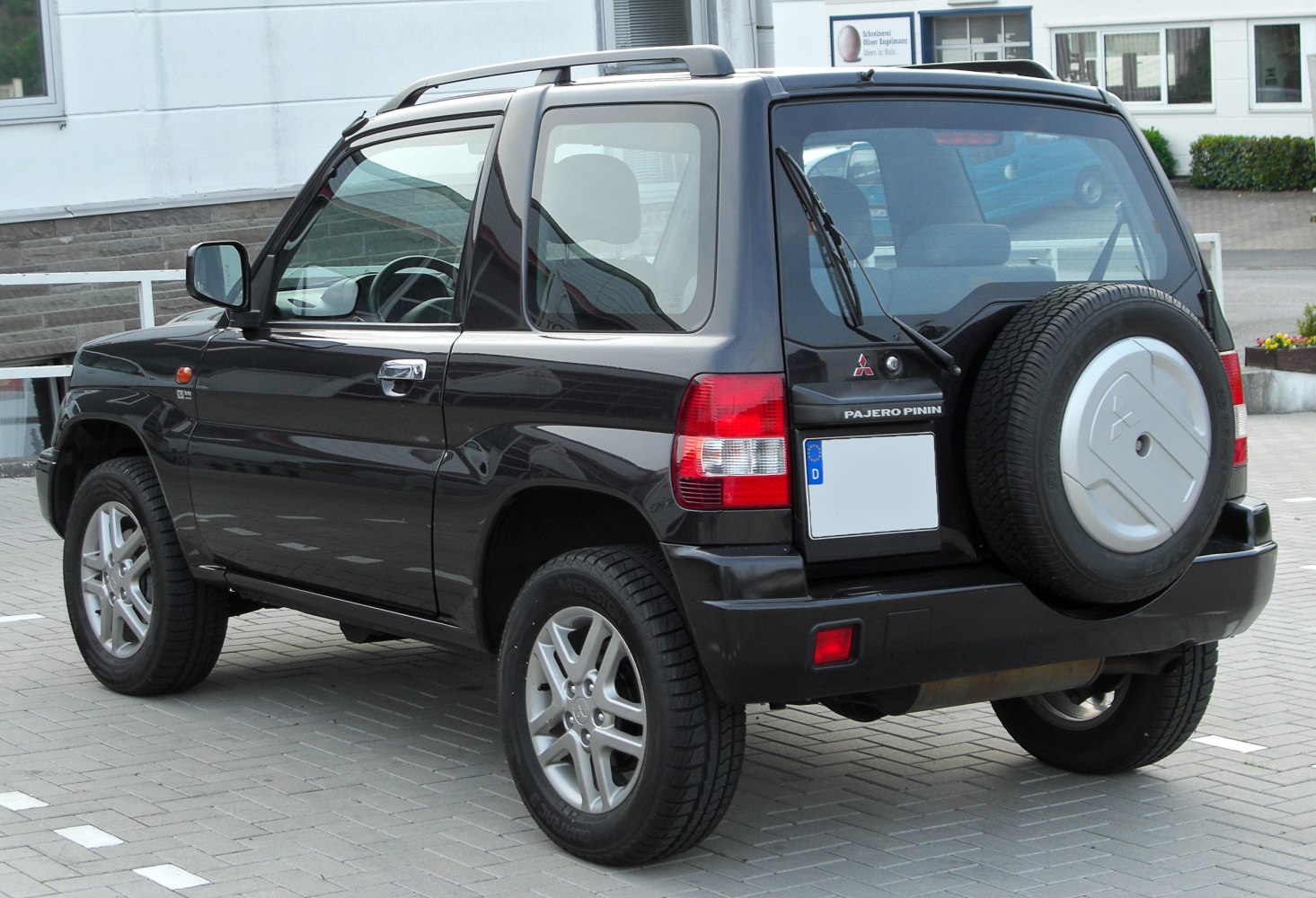 Rear and side view of compact SUV with spare wheel on tailgate