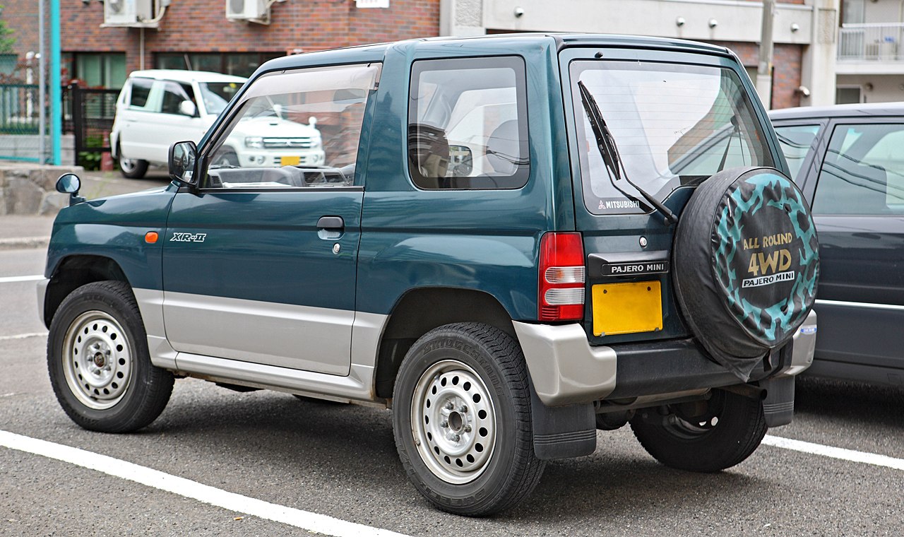Rear and side view of compact 4WD SUV with spare tire cover and steel wheels