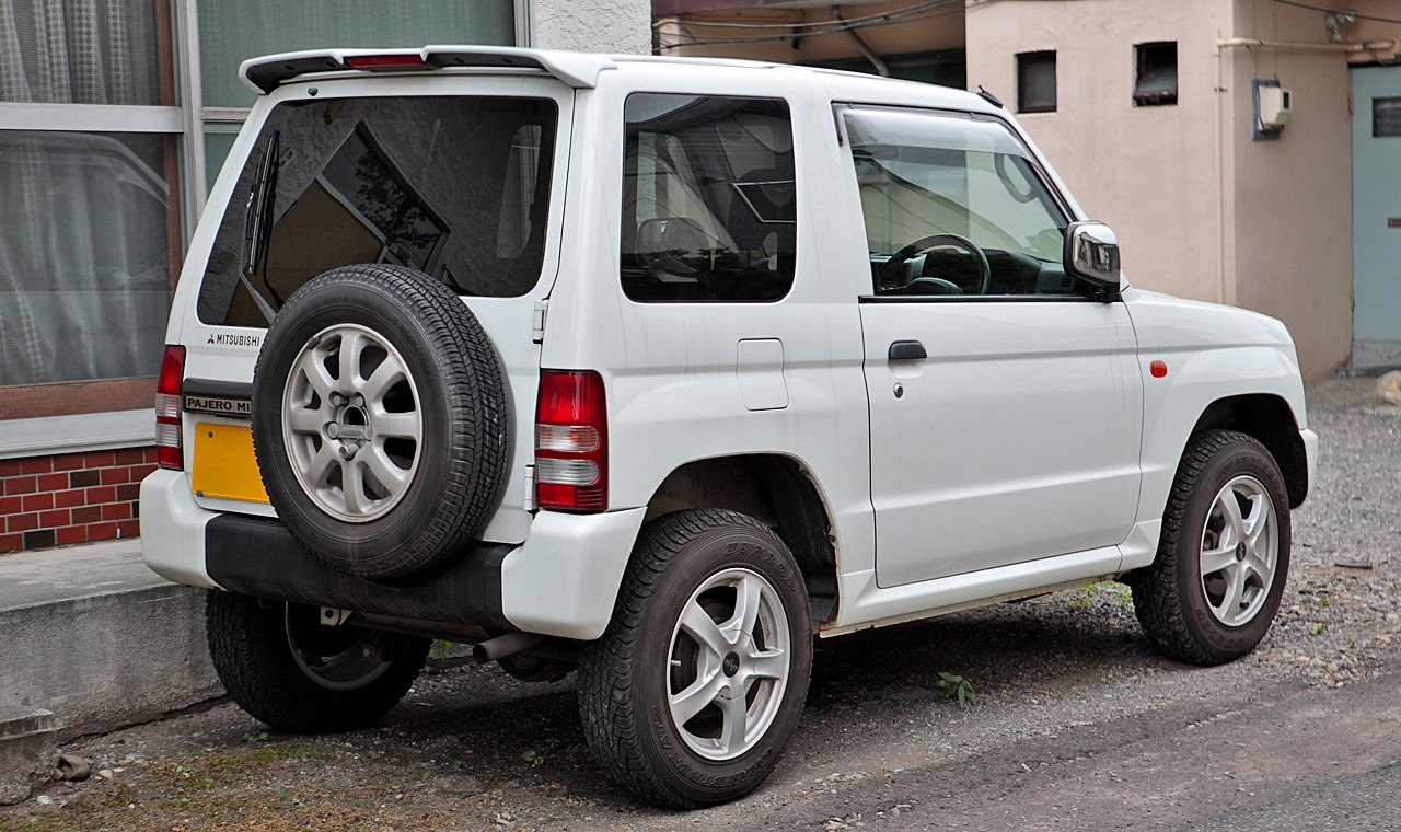 Rear side view of a compact SUV with a rear-mounted spare tire