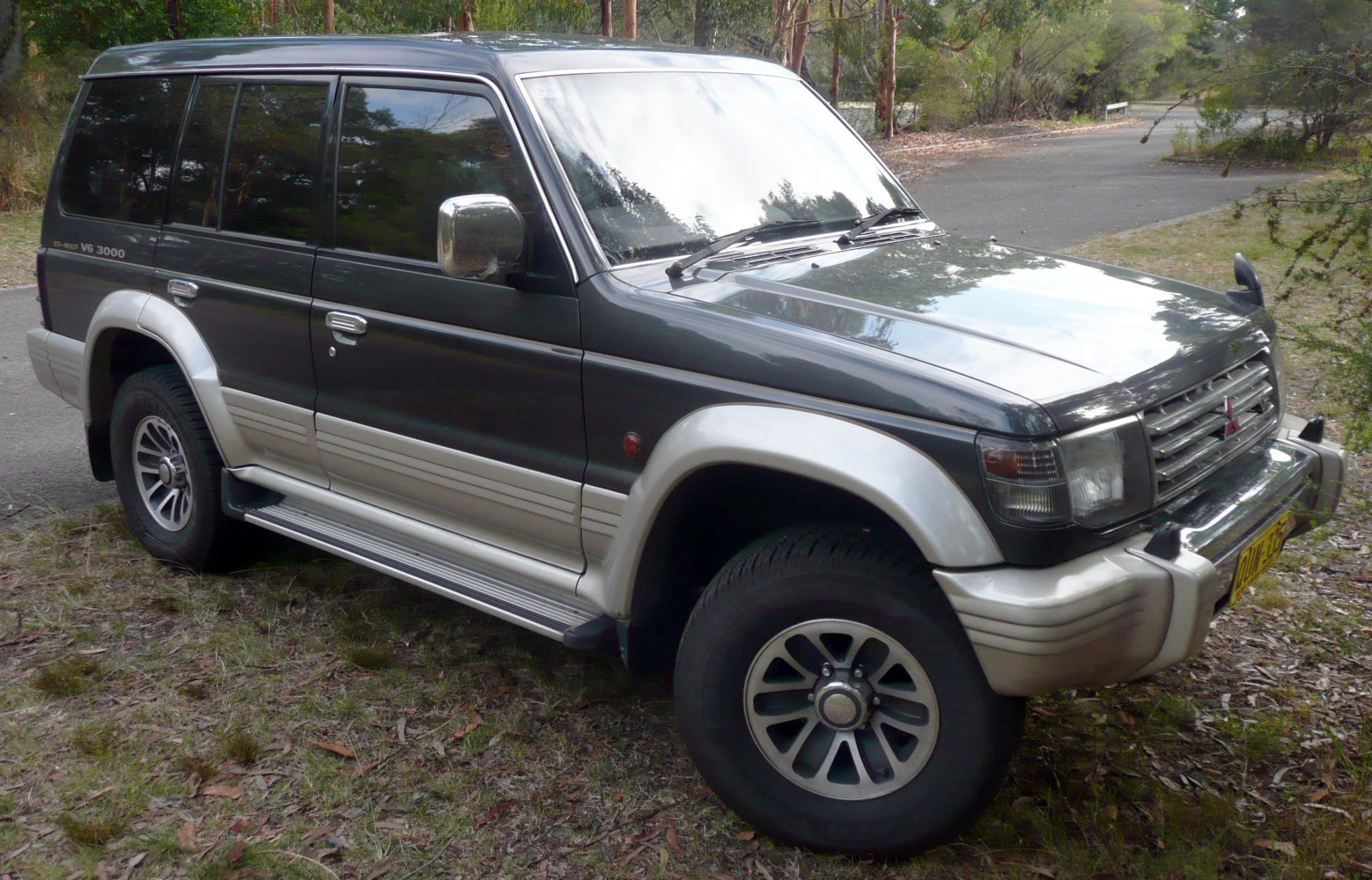 Side view of a two-tone Mitsubishi SUV with alloy wheels and V6 3000 badge