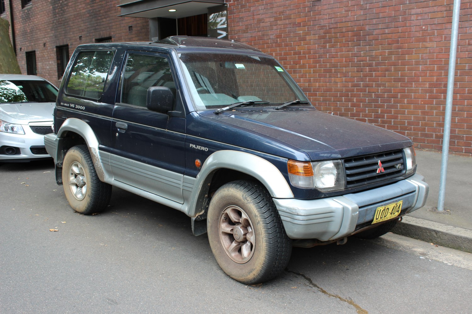 Rugged front-side view of a compact SUV with mud tires and distinct body cladding.