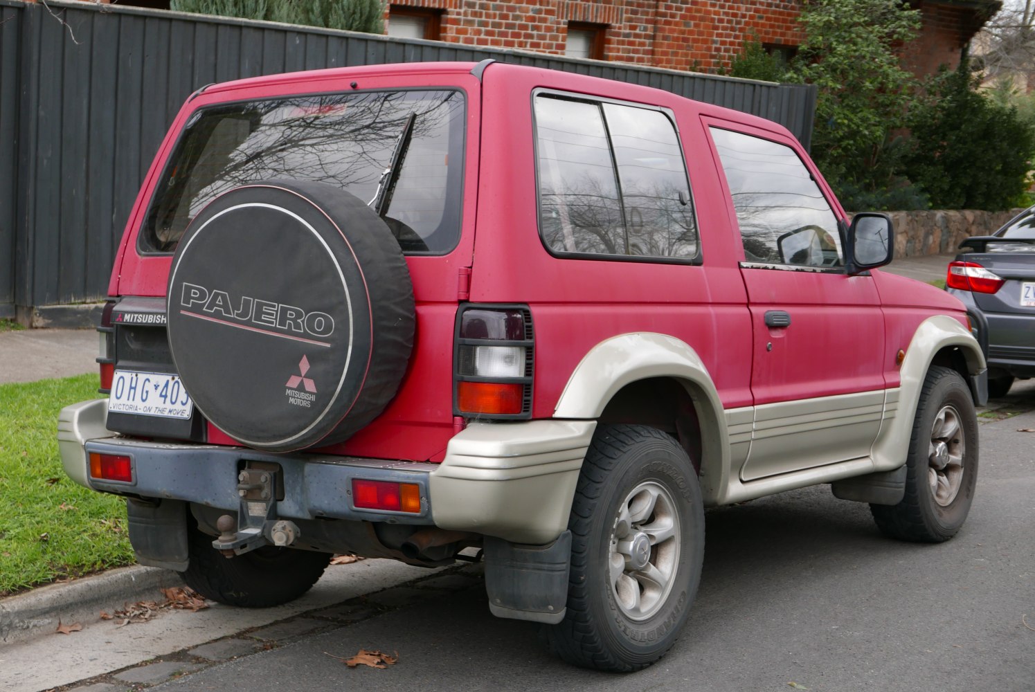 Rear view of 1990s SUV with spare tire cover and two-tone body