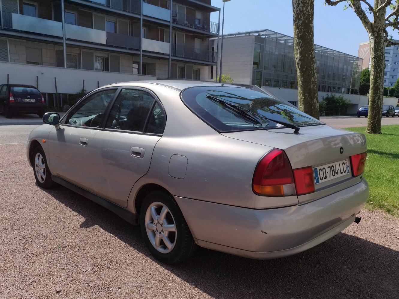 Silver hatchback rear side view with rear windshield wiper and rounded taillights