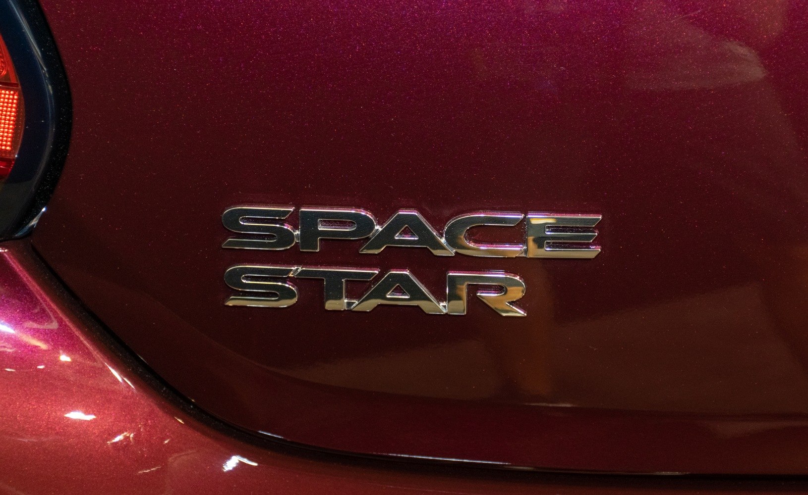 Chrome Space Star badge on metallic red paint